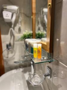 un lavandino del bagno con due bicchieri su un ripiano di vetro di Luxe Nest Guest House Apartment 22 a Luxor