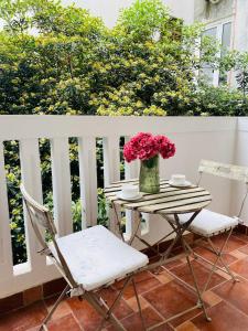 una mesa con un jarrón de flores y dos sillas en Budva Perla di Mare Hotel, en Budva