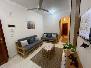 un soggiorno con due divani blu e una TV di Luxe Nest Guest House Apartment 22 a Luxor