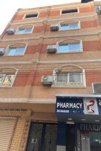 un edificio con un cartello della farmacia di fronte di Luxe Nest Guest House Apartment 22 a Luxor