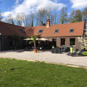 a large building with chairs and tables in a yard at Le Domaine de Wail - Legends Resort in Wail