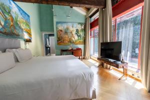 a bedroom with a white bed and a tv at Galleria Vik Milano - Townhouse Galleria - Small Luxury Hotels of the World in Milan