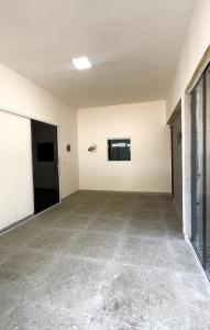 an empty room with white walls and tile floors at Casa Maroka in Japaratinga