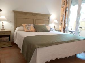 Un dormitorio con una cama grande con almohadas. en Encantadora Casita Santa Catalina, en Benaoján