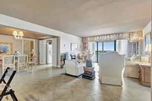 een woonkamer met een bank, stoelen en een tafel bij Luxury Two-Bedroom Oceanfront Apartment With Panoramic Views in South Palm Beach