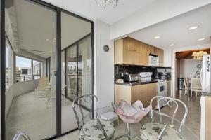 een eetkamer met tafels en stoelen en een keuken bij Luxury Two-Bedroom Oceanfront Apartment With Panoramic Views in South Palm Beach +23 foto's