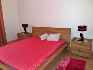 a bedroom with a large red bed with two lamps at Quinta da Mina in Monsanto