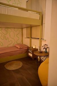 久姆里Buna Guest House的一间卧室配有一张双层床和一张桌子