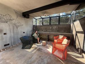 una persona seduta su una sedia in una stanza con finestra di Alta Canastra a Delfinópolis