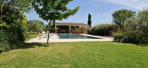 ein Swimmingpool in einem Hof mit einem Pavillon in der Unterkunft La Bastide des Muriers in Gargas