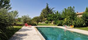 einen Pool mit roten Stühlen neben einem Haus in der Unterkunft La Bastide des Muriers in Gargas