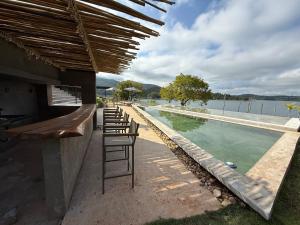 un bar con una fila di sedie accanto a una piscina di Alta Canastra a Delfinópolis