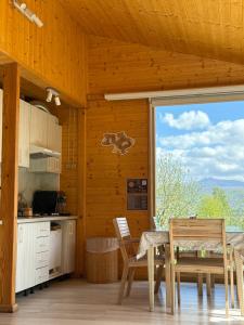a kitchen with a table and chairs and a large window at Berdo Svaliava in Svalyava