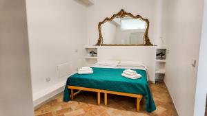 een kamer met een bed met een spiegel aan de muur bij The Gualdo Hideaway in Gualdo Tadino