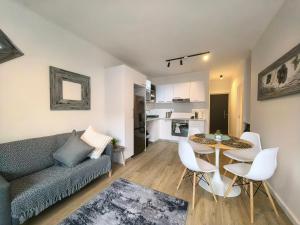 a living room with a couch and a table and chairs at Luxury Apartment Unit 111 Le Jardin in George