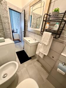un bagno con un water bianco e un lavandino di Appartamento al mare a Rimini