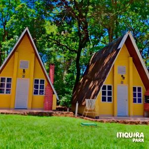 Itiquira Park Hotel في فورموزا: منزل أصفر به سلة كرة سلة في الفناء