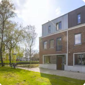 ein großes Backsteingebäude mit einem Rasenhof daneben in der Unterkunft Studio Mokum in Amsterdam