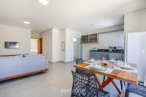 a kitchen and living room with a table and chairs at Apto c/ churrasqueira a 190m da Praia MBU0102 in Barra Velha