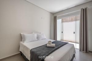 a bedroom with a bed and a large window at Apto c/ churrasqueira a 190m da Praia MBU0102 in Barra Velha