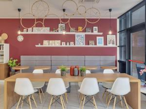 Un comedor con una mesa y sillas blancas. en B&B Hotel Como Camerlata, en Como