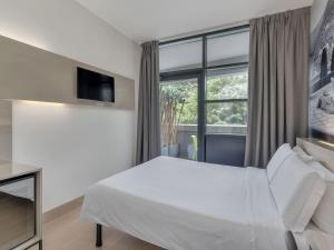 Un dormitorio con una cama y una ventana grande. en B&B Hotel Como Camerlata, en Como