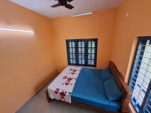 een slaapkamer met een bed en een plafondventilator bij Casa Tangerina in Varkala +7 foto's