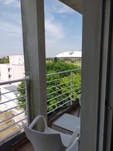 a balcony with a white chair and a view at Torre 1 Estadio Unico in La Plata