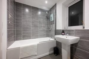 a bathroom with a sink and a bath tub next to a sink at Stowe Hideout in Hilton +30 photos