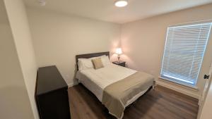 een kleine slaapkamer met een bed en een raam bij Immaculate 4BR New Construction Home in Lubbock