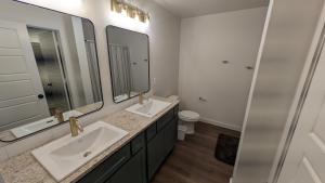 een badkamer met twee wastafels en twee spiegels bij Immaculate 4BR New Construction Home in Lubbock +15 foto's