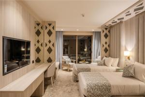 Una habitación de hotel con dos camas y un televisor. en Petra Pillars Luxury Hotel, en Petra