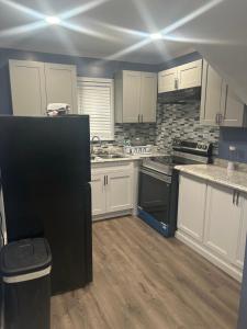 メンフィスにあるBannock placeの白いキャビネットと黒い冷蔵庫のあるキッチン