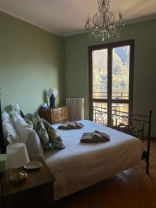 a bedroom with a bed with a chandelier and a window at Dimora Paradise in Laglio