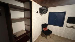 uma sala com uma cadeira e uma porta azul em Hospedagem do Iago em Cabo Frio