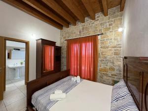 Stunning view Pool Garden AC Private parking في مارينيلا دي سيلينونتي: غرفة نوم بها سرير وجدار من الطوب