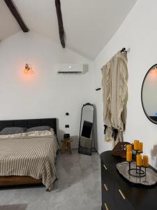 een slaapkamer met een bed, een spiegel en een dressoir bij Villa Forgione in Grottaminarda