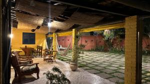 um pátio com cadeiras, uma mesa e uma rede de descanso em Hospedagem do Iago em Cabo Frio