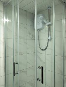 a shower with a shower head in a bathroom at Modern 3-bed Serviced Appartement - Milnsbridge in Lindley