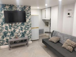 a living room with a couch and a tv on a wall at Modern 3-bed Serviced Appartement - Milnsbridge in Lindley