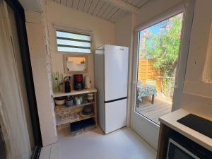 a white refrigerator in a kitchen with a window at Studio sucrier 150m des plages orient bay in Orient Bay +9 photos