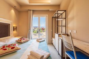 une chambre avec un lit, un bureau et une fenêtre dans l'établissement Sogno, à Tortolì