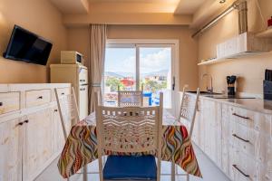 une cuisine avec une table et des chaises et une fenêtre dans l'établissement Sogno, à Tortolì