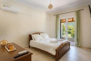 a bedroom with a bed and a desk and a window at Elite Villa Dio in Áno Korakiána +35 photos