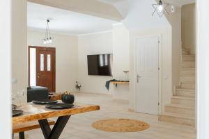 a living room with a table and a staircase at Elite Villa Dio in Áno Korakiána