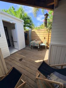 um pátio com cadeiras e uma mesa num alpendre em Studio sucrier 150m des plages orient bay em Orient Bay