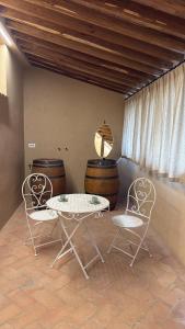 a table and two chairs in a room with barrels at Podere Gorette in Poggibonsi +7 photos