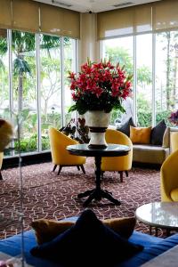 una hall con un tavolo con un vaso di fiori sopra di Astanaraya Suites Hotel a Giacarta Altre 88 foto