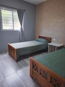 een slaapkamer met twee bedden en een raam erin bij Entre Sierras Cabañas in Tanti