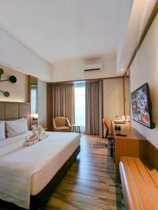 a hotel room with a large bed and a desk at Astanaraya Suites Hotel in Jakarta +88 photos